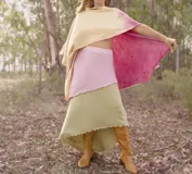 Ruana de lana merino con estampado de hojas y flores en tonos amarillos y naranjas.