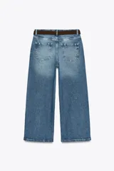 Pantalón de jean azul de corte culotte, tiro alto, pernera ancha y corta. Incluye cinturón marrón de gamuza con hebilla metálica.