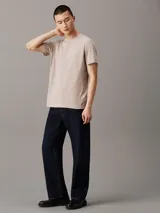 Remera color beige de algodón, con cuello redondo y mangas cortas. Cinta lateral con logo de la marca.