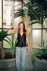 Top negro satinado con escote corazón y detalle de encaje floral en el busto y tirantes finos.