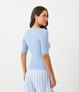Blusa de punto color durazno, con cuello barco y mangas cortas.
