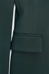 Blazer marrón de corte entallado, con cuello solapa, manga larga, bolsillos delanteros con solapa y cierre frontal con un botón.