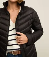 Campera puffer ultraligera color marrón, confeccionada en poliamida acolchada, con cuello alto y cierre por cremallera. Incluye bolsita con cordón.