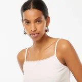 Camiseta sin mangas rosa de canalé con tirantes finos y detalle de encaje con moño en el escote.