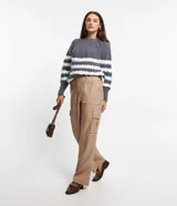 Pantalón recto color beige de material sintético, con trabillas en la cintura, cierre delantero, cintura elástica en la espalda y bolsillos laterales tipo cargo.