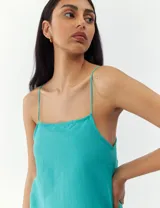 Vestido corto color crema con breteles finos y corte recto.
