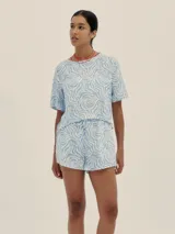 Conjunto de short y remera con estampado abstracto en tonos celeste y blanco. El short tiene pretina con elástico y detalle de Polonio en cobre.