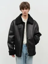 Chaqueta negra de cuero vegano con forro de sherpa, solapas con hebillas, cuello italiano, cierre de cremallera y mangas con puños.