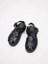 Sandalias negras tipo gladiador con plataforma de goma y hebilla metálica.