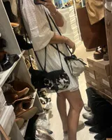 Bandolera marrón de cuero gamuzado con solapa de cuero liso y cierre con tira de cuero con botón a presión.