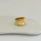 Anillo dorado de acero quirúrgico hipoalergénico con baño en oro 18K, de diseño grueso y forma irregular.