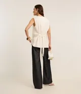 Chaleco largo color crema, con botones delanteros y lazo en la espalda.