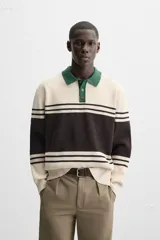 Polo de corte relajado confeccionado en tejido de punto con textura de chenilla. Presenta cuello de solapa con cierre frontal de botonadura, mangas largas y acabados en rib.