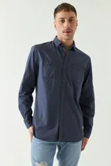 Camisa de gabardina gris con corte slim, mangas largas, cartera abotonada y dos bolsillos con solapa en el pecho.