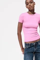 Camiseta rosa de viscosa, corte slim fit, cuello redondo y manga corta.