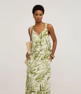 Pollera midi evasé de mujer, con cintura elástica y estampado de follaje en tonos verdes sobre fondo blanco.