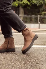 Bota corta de cuero color marrón, con suela track y cierre lateral con cremallera.