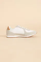 Zapatillas deportivas blancas con detalles en gris y marrón claro.