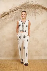 Pantalón de lino color crema con bordados florales negros.