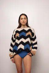 Buzo tejido a mano con lana merino, estilo oversized con diseño de ondas en colores blanco, negro, azul y marrón.