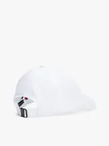 Gorra de béisbol blanca de algodón con diseño de seis paneles, ojales de ventilación, botón en la parte superior y hebilla de ajuste metálica en la parte trasera. Presenta un monograma TH bordado en negro en la parte delantera.