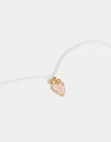 Collar corto con cadena dorada y perlas sintéticas. Dije de corazón esmaltado en rosa con borde dorado y detalle de moño dorado en la parte superior.