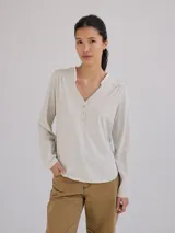 Remera color gris claro con cuello en V y volados de lino en el cuello.