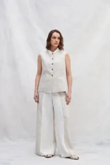 Chaleco color crema de lino, con cuello mao, cierre frontal con botones y bolsillos ojal a contratono.