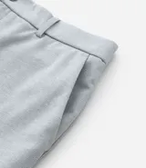 Pantalón de vestir gris con textura, corte slim, con trabillas en la cintura y cierre por botón y cremallera.