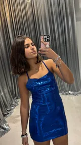 Vestido corto azul con lentejuelas, escote drapeado y tirantes finos.