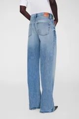 Jean de corte relajado y pierna ancha, inspirado en los años 90. Confeccionado en denim rígido de algodón orgánico, presenta tiro medio, cierre con botones y ruedo con terminación al corte.