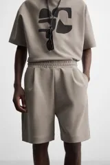 Bermuda relaxed fit color blanco confeccionada en tejido interlock de algodón con elasticidad. Cintura elástica ajustable con cordón interior. Bolsillos laterales y detalle de bolsillo trasero de plastrón.