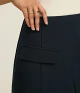 Short pollera de tiro alto color verde oliva, de corte sastrero con solapas delanteras simulando bolsillos y recorte en V en el ruedo.