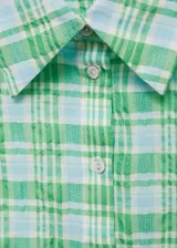 Camisa sin mangas a cuadros verdes y celestes, con cuello camisero y cierre frontal con botones.