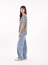Remera blanca con estampado de ojos y pestañas en negro.