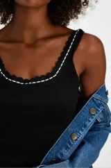 Musculosa negra de algodón con escote redondo y breteles finos con detalle de puntilla blanca.