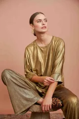 Top dorado amplio con escote redondo y mangas murciélago.