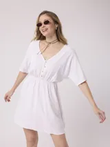 Vestido corto blanco de algodón y lino, con escote en V, mangas cortas y cintura elastizada. Cierre frontal con botones.