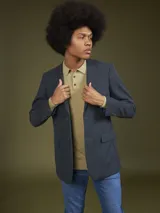 Blazer gris oscuro de corte clásico, con solapas de muesca, cierre de dos botones y bolsillos de parche.