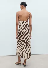 Vestido midi con estampado animal print de cebra en tonos marrón y beige. Presenta tirantes finos ajustables y escote drapeado. El corte es recto y tiene cierre lateral invisible.