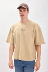 Remera color tostado de manga corta con estampa en el frente.