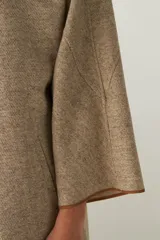 Tapado marrón de largo medio, abierto, con cuello y envivado. Hecho 100% en Uruguay con tela 100% lana fina sin teñir, diseñada exclusivamente por Don Baez.