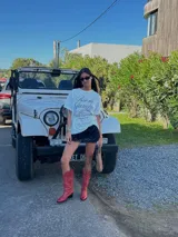 Botas de caña alta estilo cowboy, color rojo brillante, con bordados decorativos en hilo blanco contrastante. Presentan punta afilada y tacón bajo y angular.