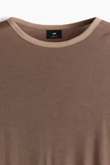 Remera marrón de corte recto con cuello redondo y ribete en color beige en cuello y mangas.
