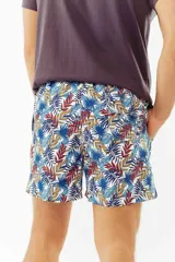 Short de baño con estampado de hojas de palmera en tonos celeste y naranja.