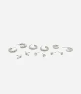 Set de aros plateados con diferentes diseños: aros tipo argolla torcida, aros con strass, aros orgánicos, aros tipo botón y aros con forma de barra.