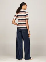 Chomba de piqué de algodón elástico con estampado de rayas horizontales en azul marino, rojo y blanco. Tiene cuello polo blanco con ribete distintivo, tapeta de cinco botones y logo de Tommy Hilfiger bordado en el pecho.
