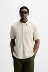 Camisa celeste de corte recto, manga corta y cuello solapa.
