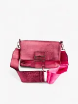 Bandolera de cuero color fucsia con correa ancha de cinta de seguridad rosa y cierre con botón magnético.