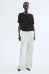 Remera de manga corta en punto fino de mezcla de viscosa, color negro. Presenta escote redondo, puños y bajo en punto acanalado.